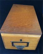 A wooden filing drawer with brass cup handle