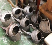 A large selection of metal watering cans.