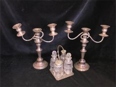 A selection of silver plated ware to include two three arm candlesticks and a cruet set.