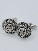 A pair of large silver cuff links depicting Lions