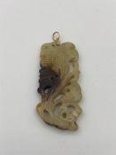A Chinese white jade pendant on gold setting.