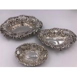 Three assorted silver pin trays with repousse design.