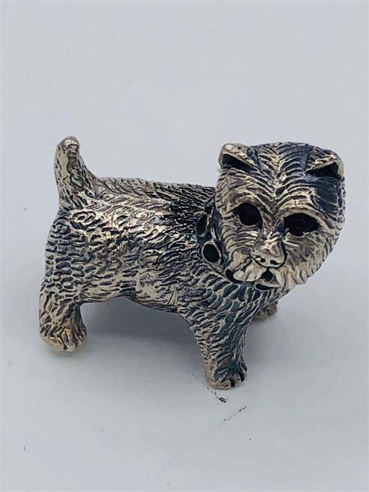 A silver cast figure of a dog