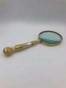 A large hand held brass magnifying glass