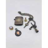 A silver albert chain, vesta case and assorted charms.