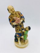 A Japanese figure of a man and his child holding a dove