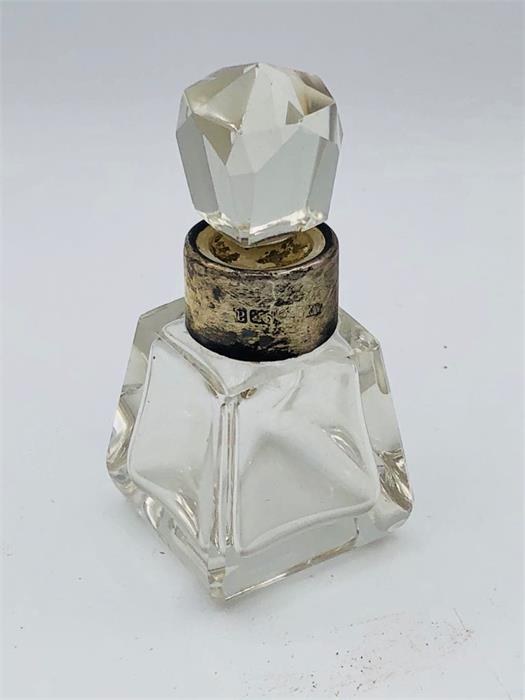 A cut glass perfume bottle with hallmarked silver collar