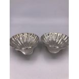 A Pair of silver butter dishes in the form of scallop shells, hallmarked Birmingham 1910 , makers