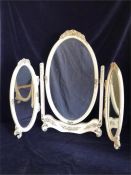 A dressing table trifold mirror with ornate detail in cream