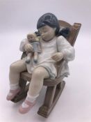 Lladro Figure 'Naptime' (12cm) Girl holding a doll in a rocking chair.