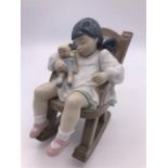 Lladro Figure 'Naptime' (12cm) Girl holding a doll in a rocking chair.