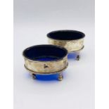A Pair of hallmarked silver salts with blue glass liners.