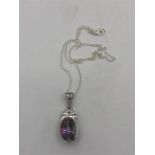 A silver necklace with a mystic Topaz stone pendant