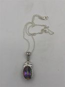 A silver necklace with a mystic Topaz stone pendant