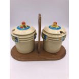A Pair of Japanese Jam jars with a floral theme on a wooden carry stand.