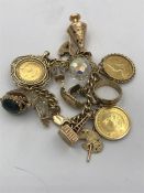 A 9ct gold charm bracelet with a number of charms to include a 1900 Sovereign, a 1910 sovereign