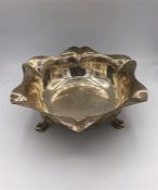 A silver bowl, hallmarked Sheffield 1930, on three legs. (410g)