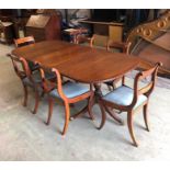 A Double pedestal dining table with centre leaf and six chairs with blue seat pads.