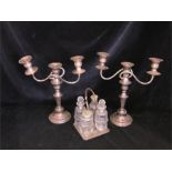 A selection of silver plated ware to include two three arm candlesticks and a cruet set.