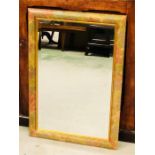A rectangular wooden framed mirror with floral motif