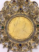 A Maria Theresa Thaler gilded in a decorative filigree mount