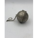 A White metal Chinese, possibly, tea ball.