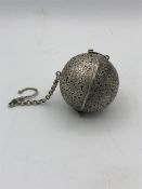 A White metal Chinese, possibly, tea ball.