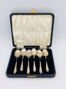 A set of silver, hallmarked teaspoons in a black case.