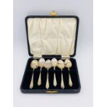 A set of silver, hallmarked teaspoons in a black case.