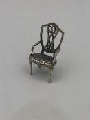 A miniature silver figure of a chair.