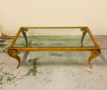 A glass and brass coffee table with ram horn style legs 130cm x 76cm, and 44cm high.