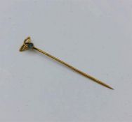 A 9ct gold lapel pin with aquamarine stone inset.