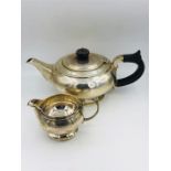 A silver teapot and milk jug. (545g)