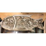 A Carved wooden plaque with a fish and tribal theme (90cm x 36cm)