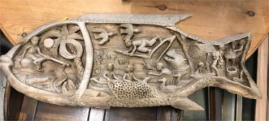 A Carved wooden plaque with a fish and tribal theme (90cm x 36cm)