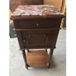 A bedside table with a red marble top.