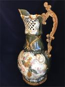 A Large majolica, green grounds, jug with ornate handle.