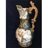 A Large majolica, green grounds, jug with ornate handle.