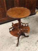 An occasional table with pedestal legs and galleried lower shelf
