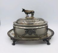 A White metal bright cut butter dish with glass loner and handle with cow finial,