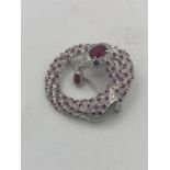 A silver brooch in the form of a snake set with rubies and CZ.