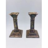 A Pair of white metal candlesticks