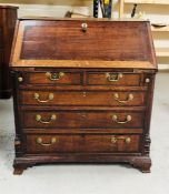 A George III oak crossbanded bureau, the fall enclosing a stepped interior with serpentine drawers