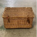 A large wicker laundry basket on castors.