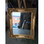 An ornate gold framed mirror 80 cm x 69cm.