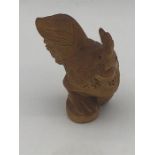 A carved wooden netsuke in the form of a cockerel.