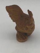 A carved wooden netsuke in the form of a cockerel.