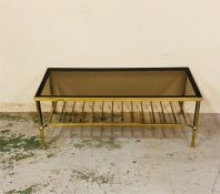 A brass long coffee table with shelf under, reeded legs and a smoked glass top.