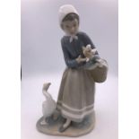 Lladro figure of a girl holding a basket with a goose by her feet