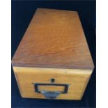 A wooden filing drawer with brass cup handle